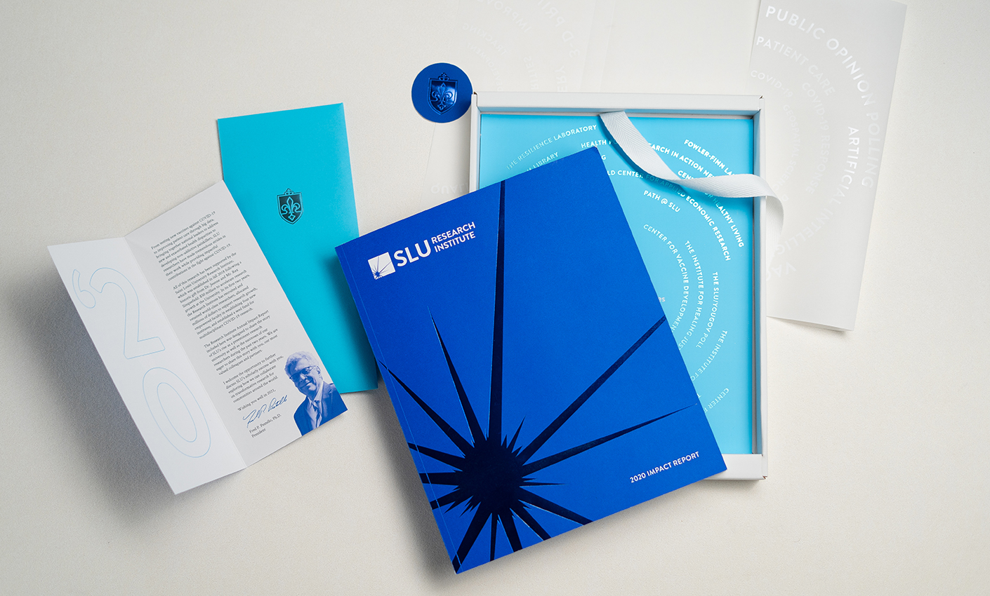A SLU annual report book splayed on a table by a higher education marketing agency