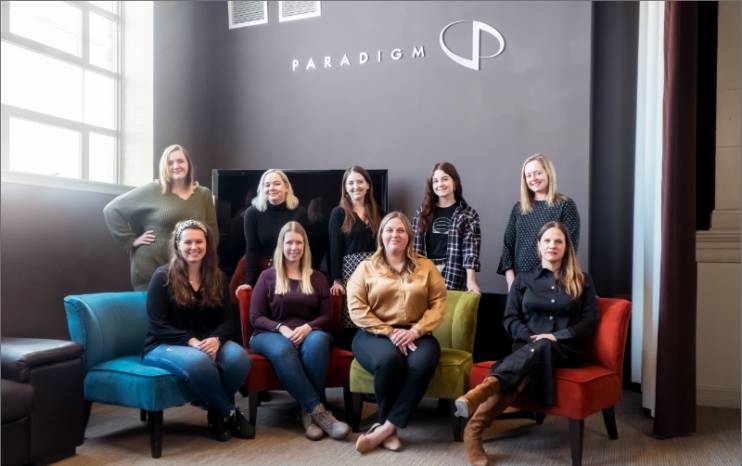 Nine of Paradigm's 10 female staff members pose for a Women's History Month photo.