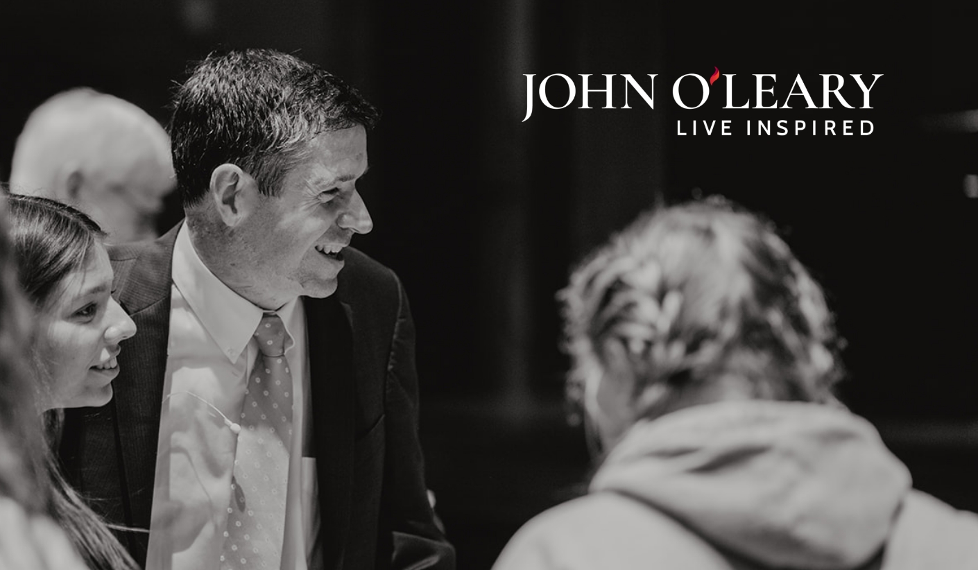 A black and white image of John next to his new logo.